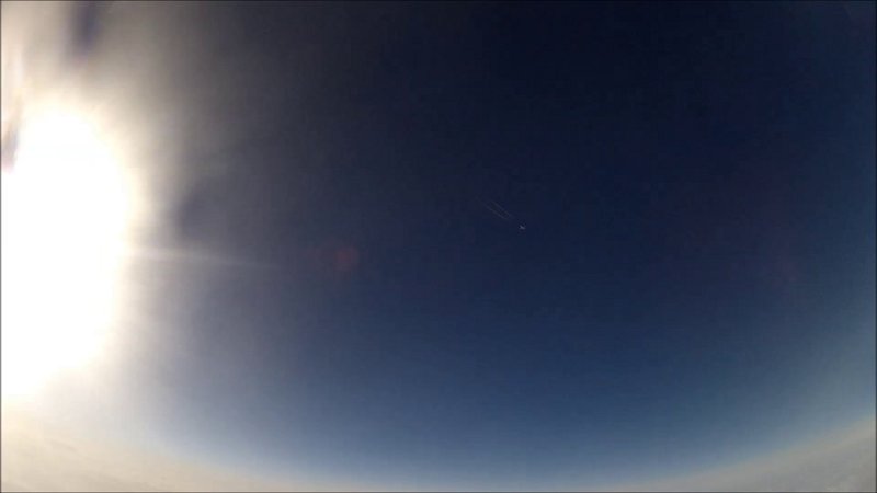 Kondensstreifen vor tiefblauem Himmel, darunter der helle Horizont